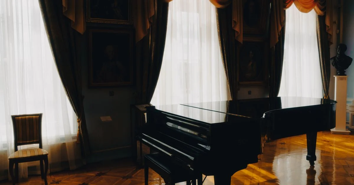 Un piano à queue dans une pièce ensoleillée avec des rideaux élégants et une décoration classique, renforçant une atmosphère luxueuse.