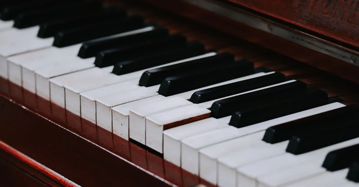 Gros plan détaillé et précis des touches d'un piano droit classique aux riches textures de bois.