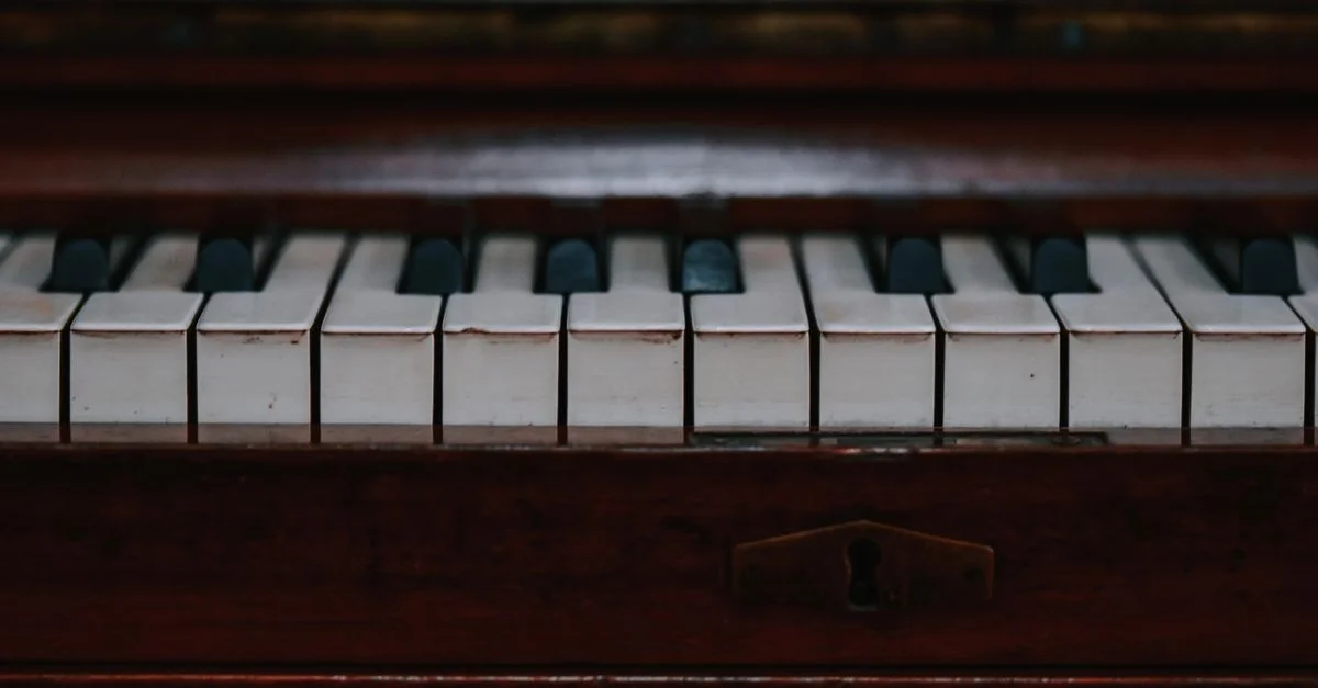 Gros plan des touches d'un piano vintage mettant en valeur leur beauté antique et classique.