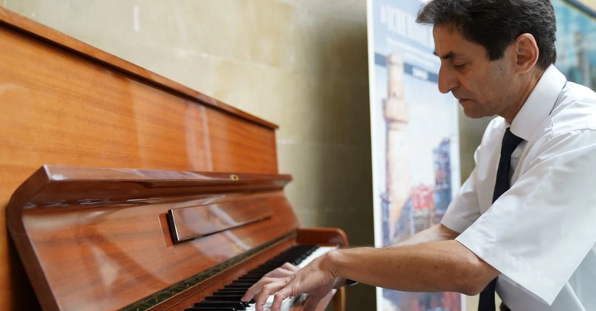 Un homme joue intensément du piano à l'intérieur à Bakı, en Azerbaïdjan.