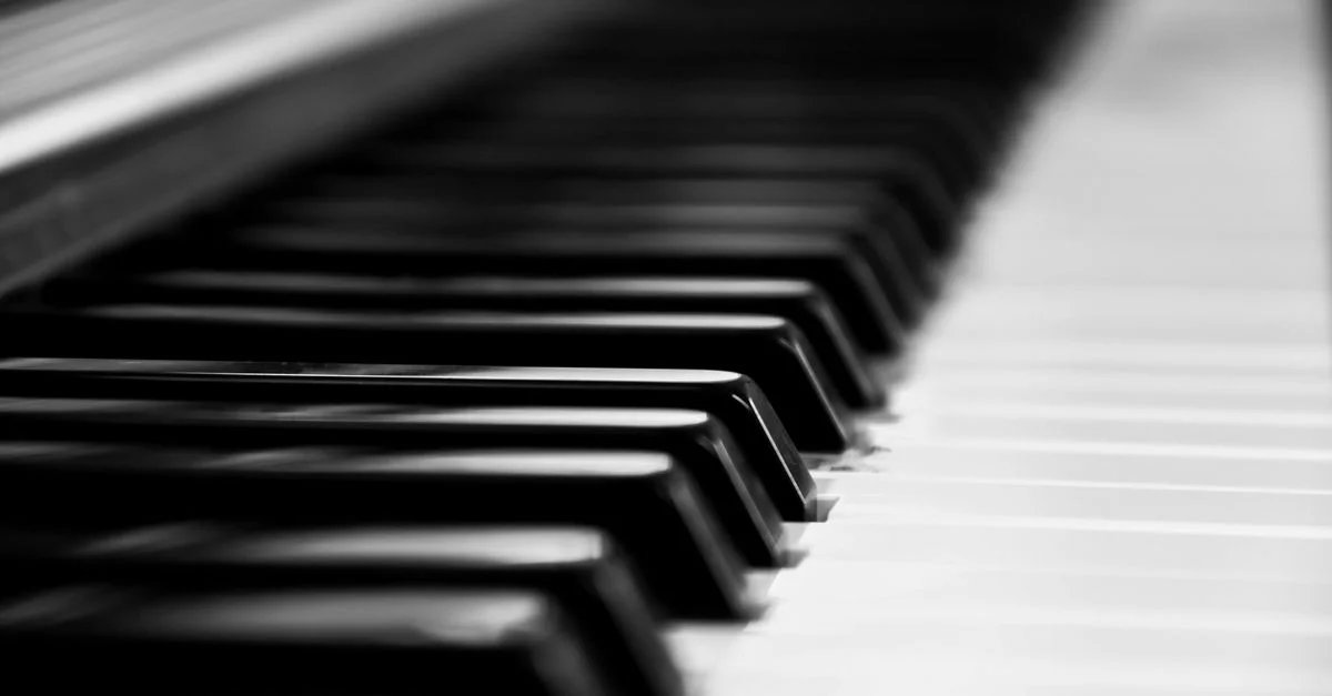 Gros plan noir et blanc des touches du piano mettant en valeur l'élégance et la beauté musicale.
