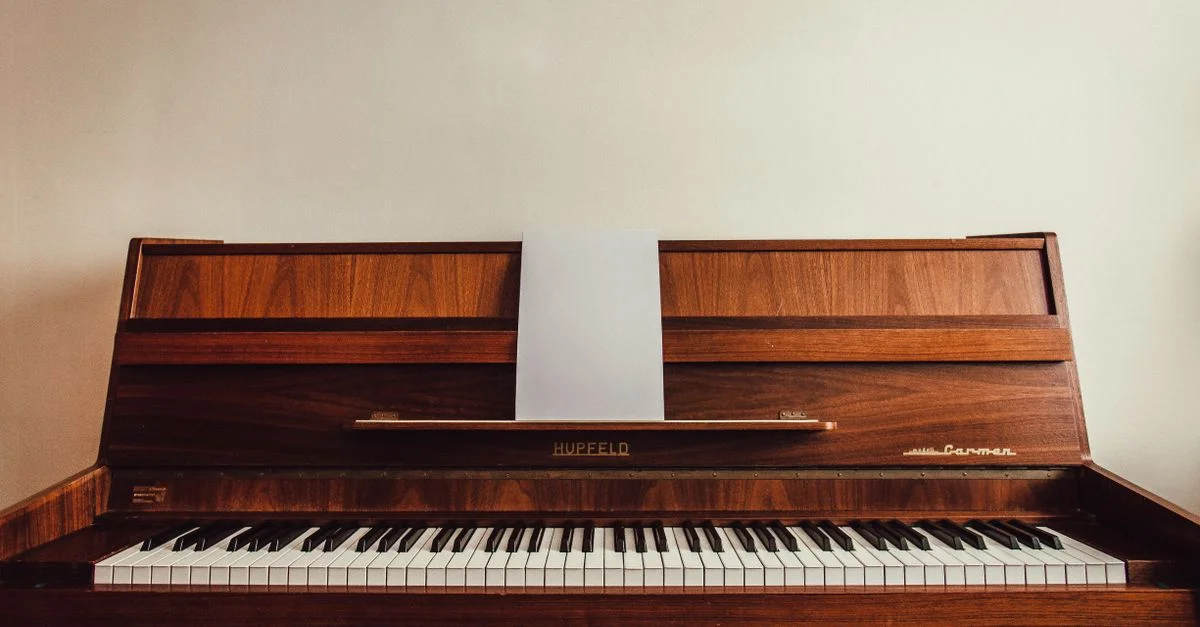 Piano droit en bois classique avec des partitions, idéal pour les amoureux de la musique.
