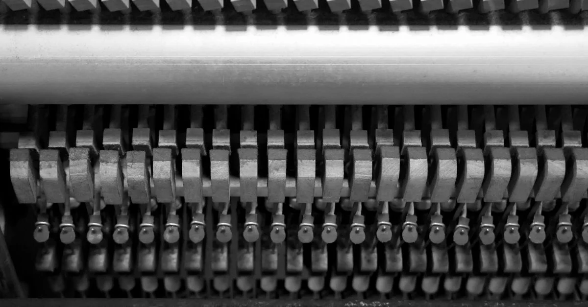 Image détaillée en noir et blanc mettant en valeur les marteaux et cordes complexes à l'intérieur d'un piano.